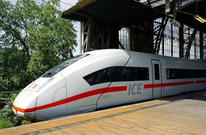 A sleek ICE train parked at Hamburg station on a sunny day.